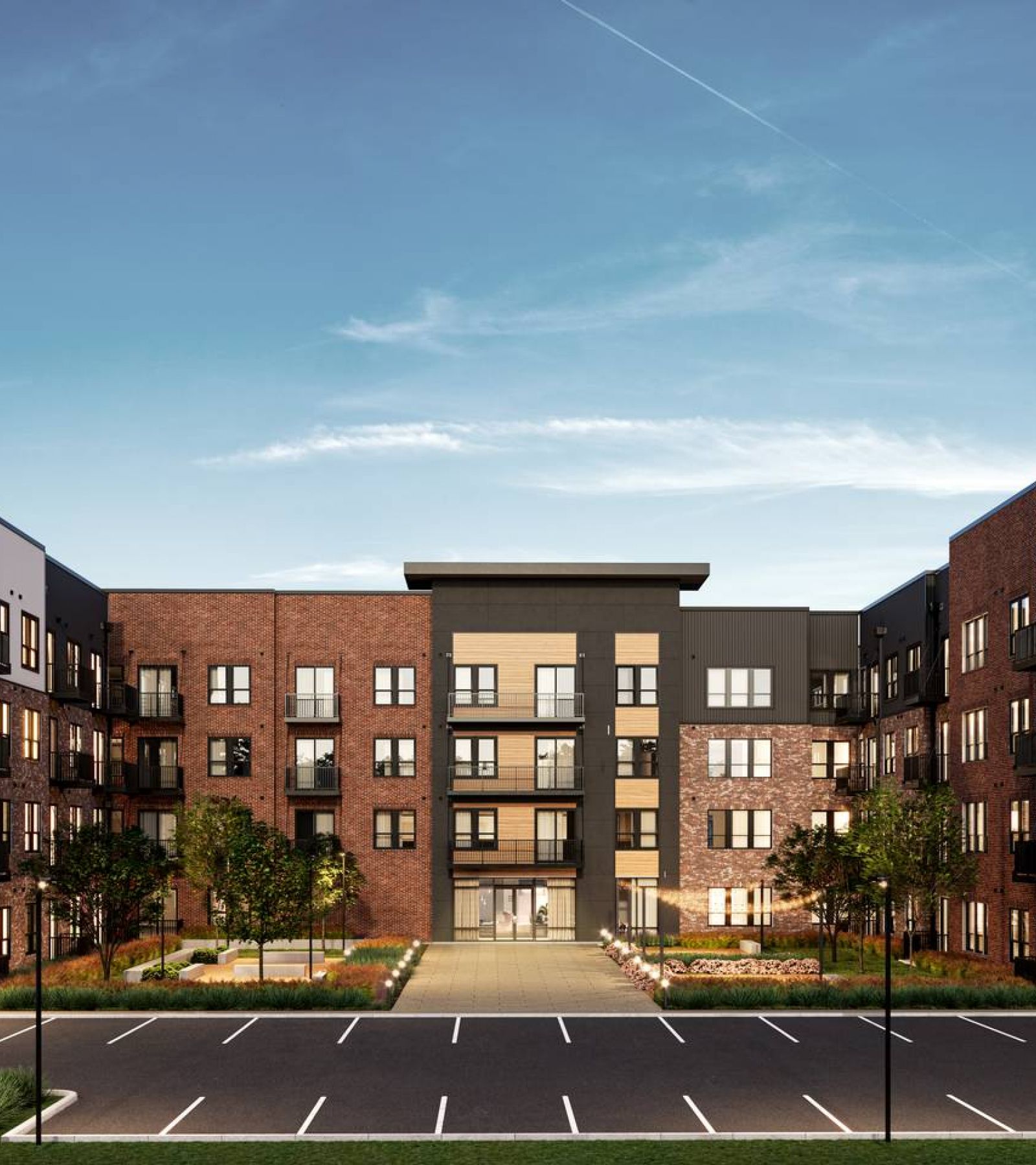 Wixby House Modern four-story apartment building with balconies and an empty parking lot under a clear blue sky.
