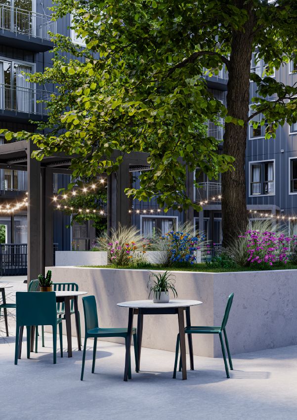 Wixby House Outdoor patio with tables and chairs, a large tree, string lights, and modern apartment buildings in the background.
