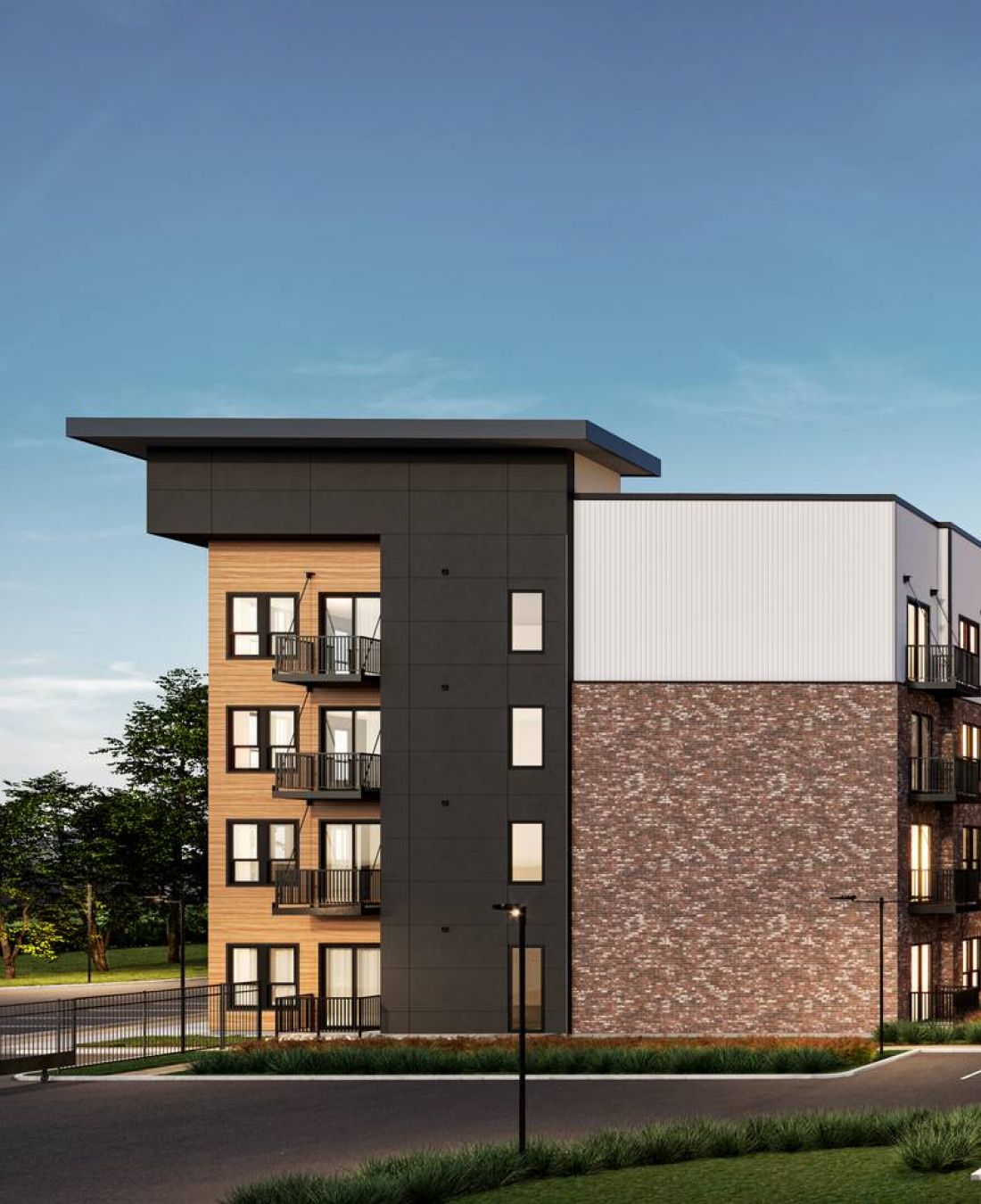 Wixby House Modern four-story apartment building with balconies and an empty parking lot under a clear blue sky.